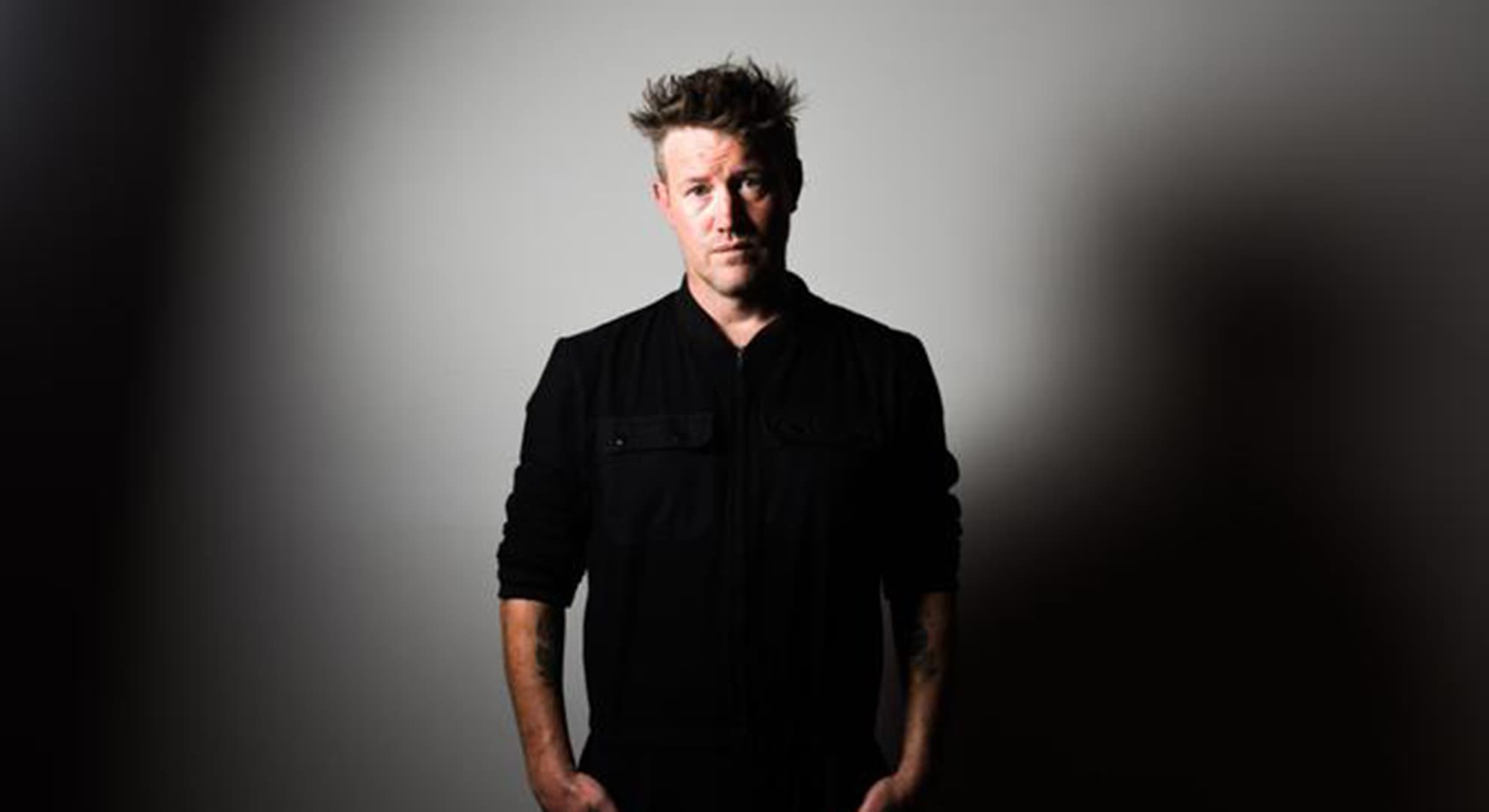 Eddie Perfect in a dark studio