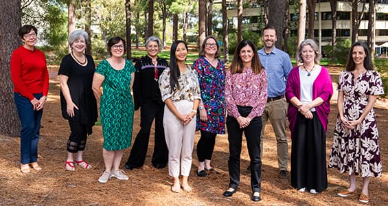 group of people standing in a forest