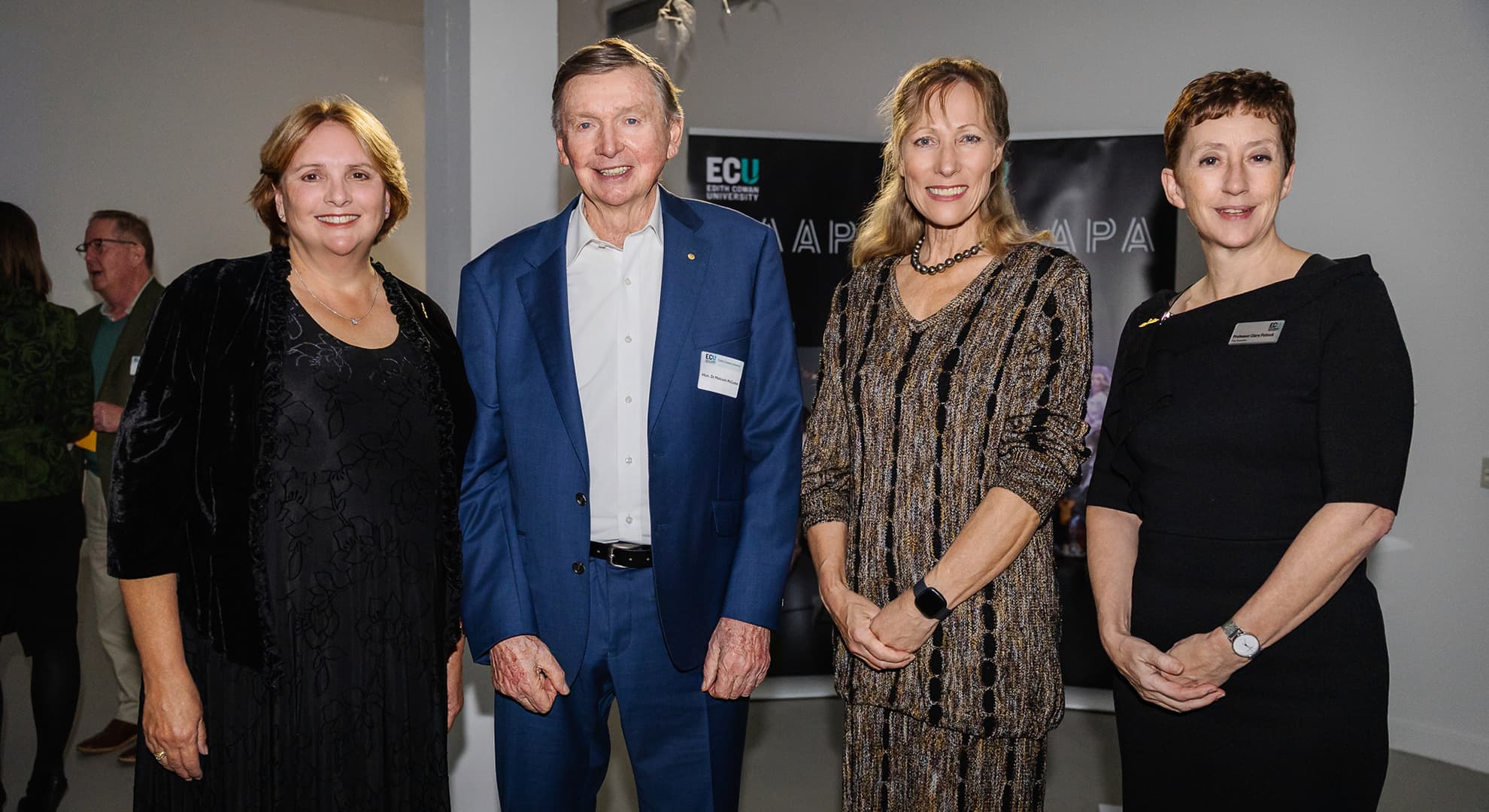 Four people standing in a row