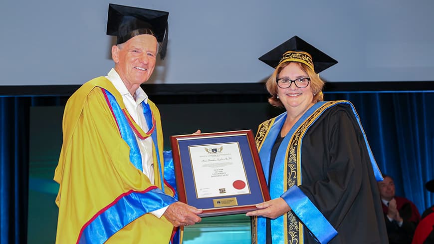 A man, Ross Taylor, receiving an award from a woman, ECU Chancellor Gaye McMath