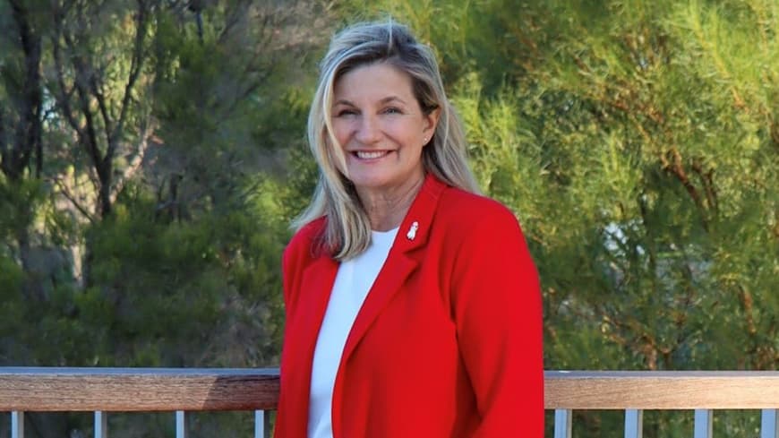 Hon Trish Cook MP wearing a bright red suit.