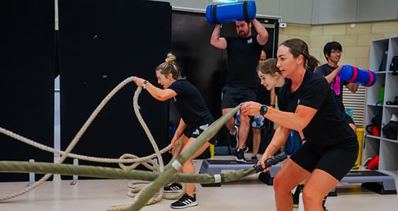 People using battle ropes in a gym