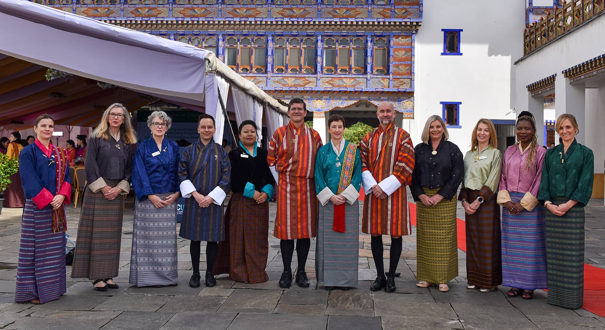 A group of people at a street market in a line facing the camera
