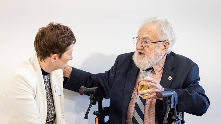 A woman and an older man facing each other talking