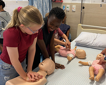 Children;s University students learning CPR with the baby dummies during the CU October School Holidays program: CU Nursing Ninjas Academy.