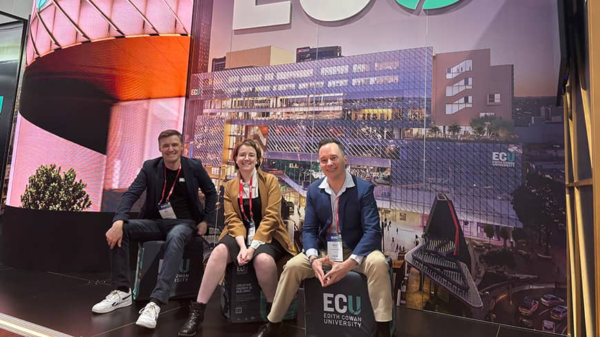 Three people at a conference booth