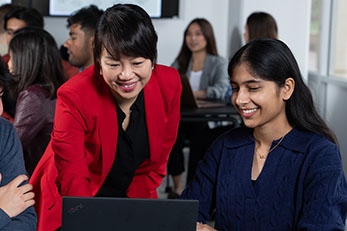 A academic staff member supports a student in a teaching setting.