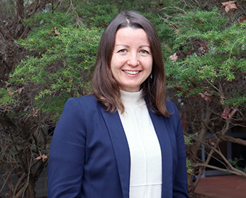 A portrait image of Dr Tetiana Bogachenko smiling in front of a tree