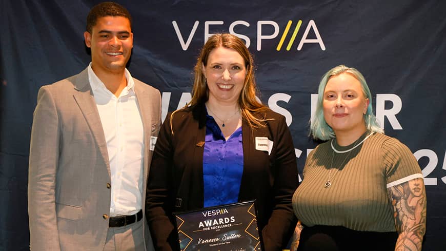 Three people posing for photos with Award certificate