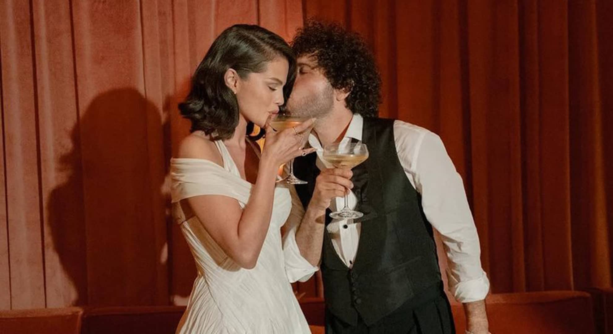 A woman and a man  posing in front of a wedding cake