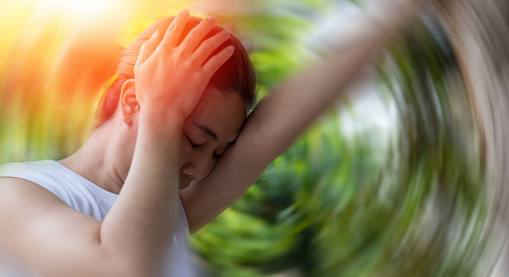 A woman holding her head, with a spinning background.