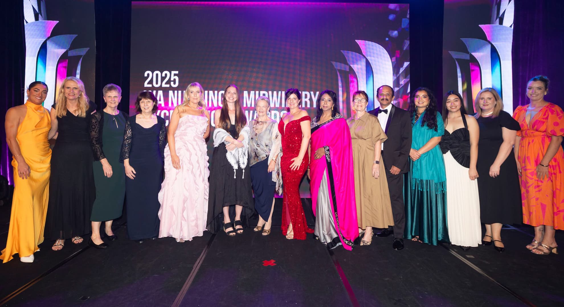 A group of nursing and midwifery professionals dressed up at a awards gala.