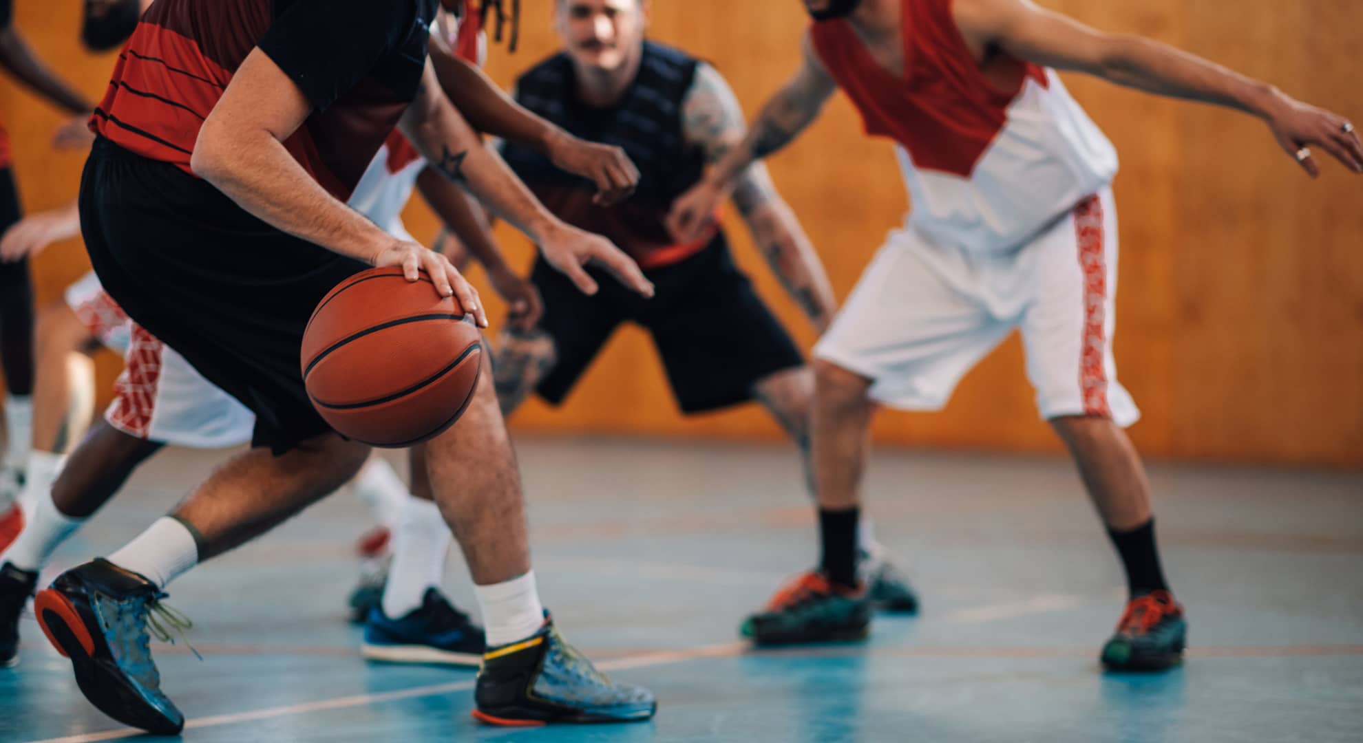A group of diverse men playing basketball.