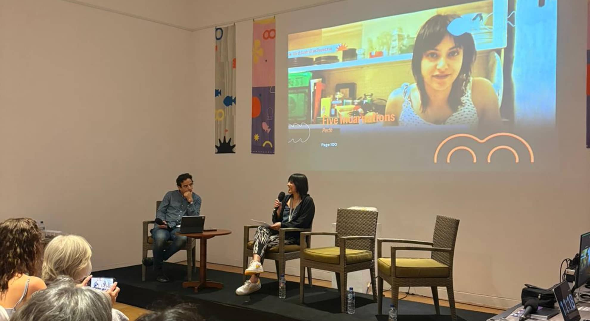 Woman presenting her film on stage in front of an audience