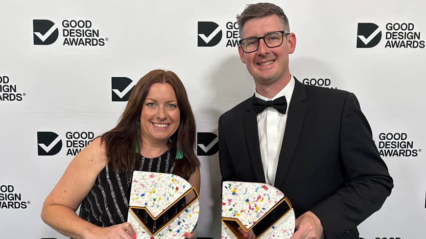 Two people standing with awards