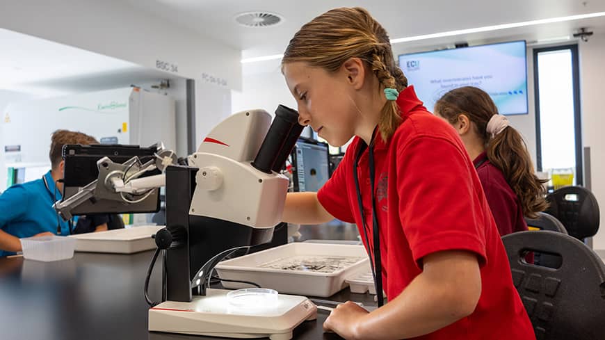 Girl looking into a microscope