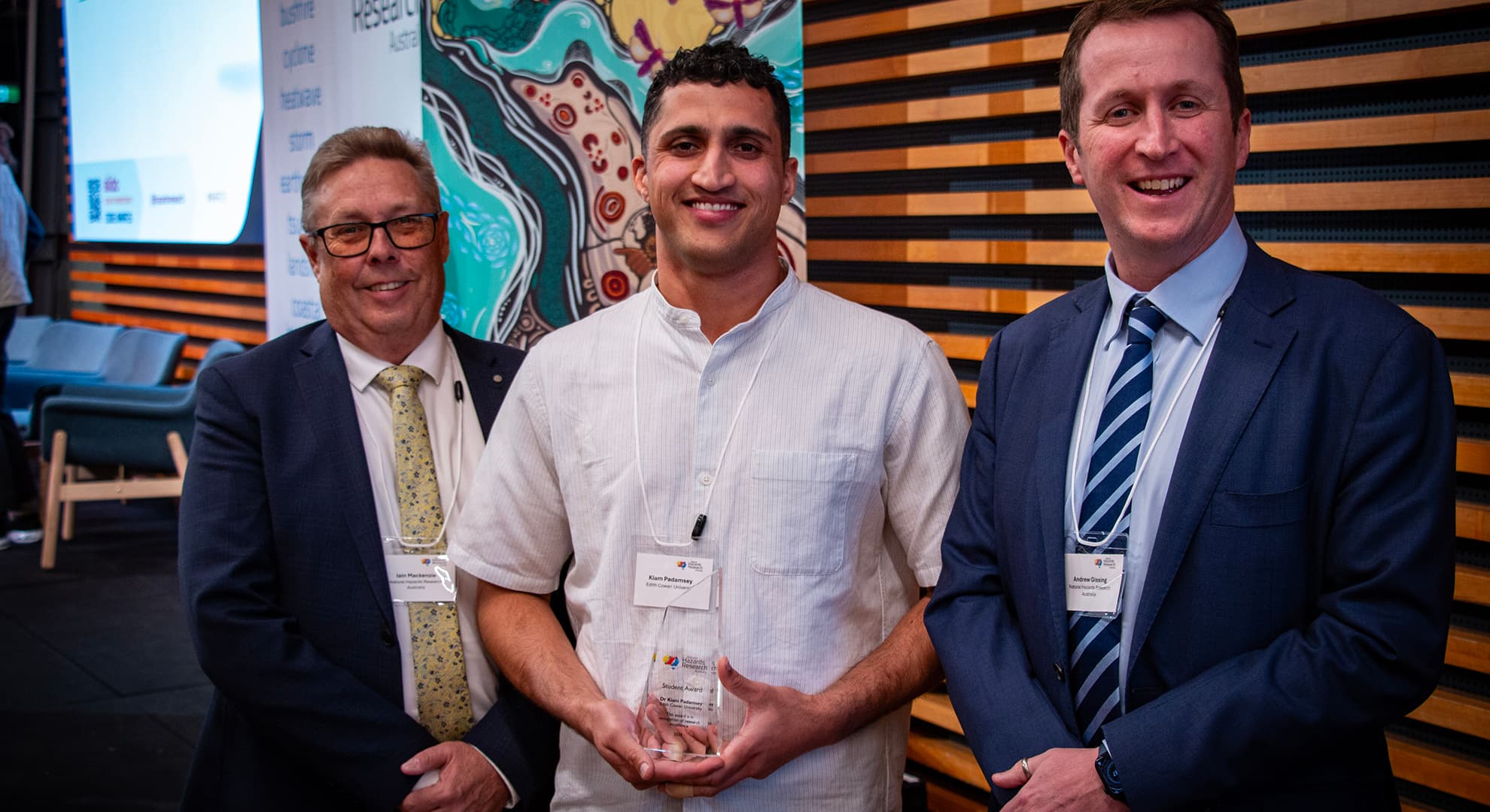 Three men posing for photo at an awards event