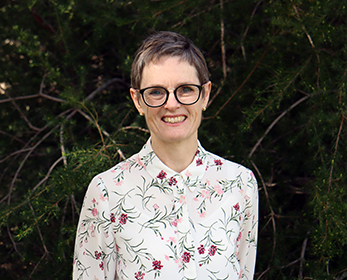 A portrait of Dr Suzanne Stewart smiling with a tree in the background