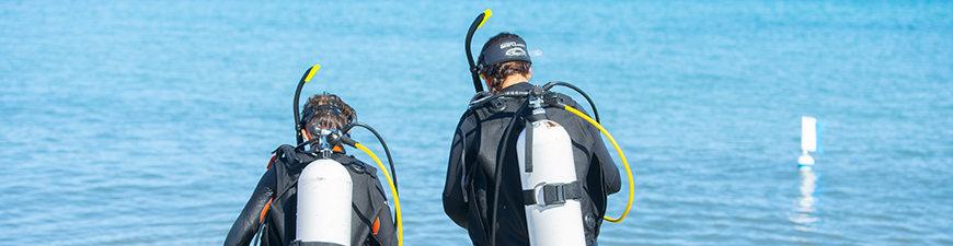 Two divers walking into the sea