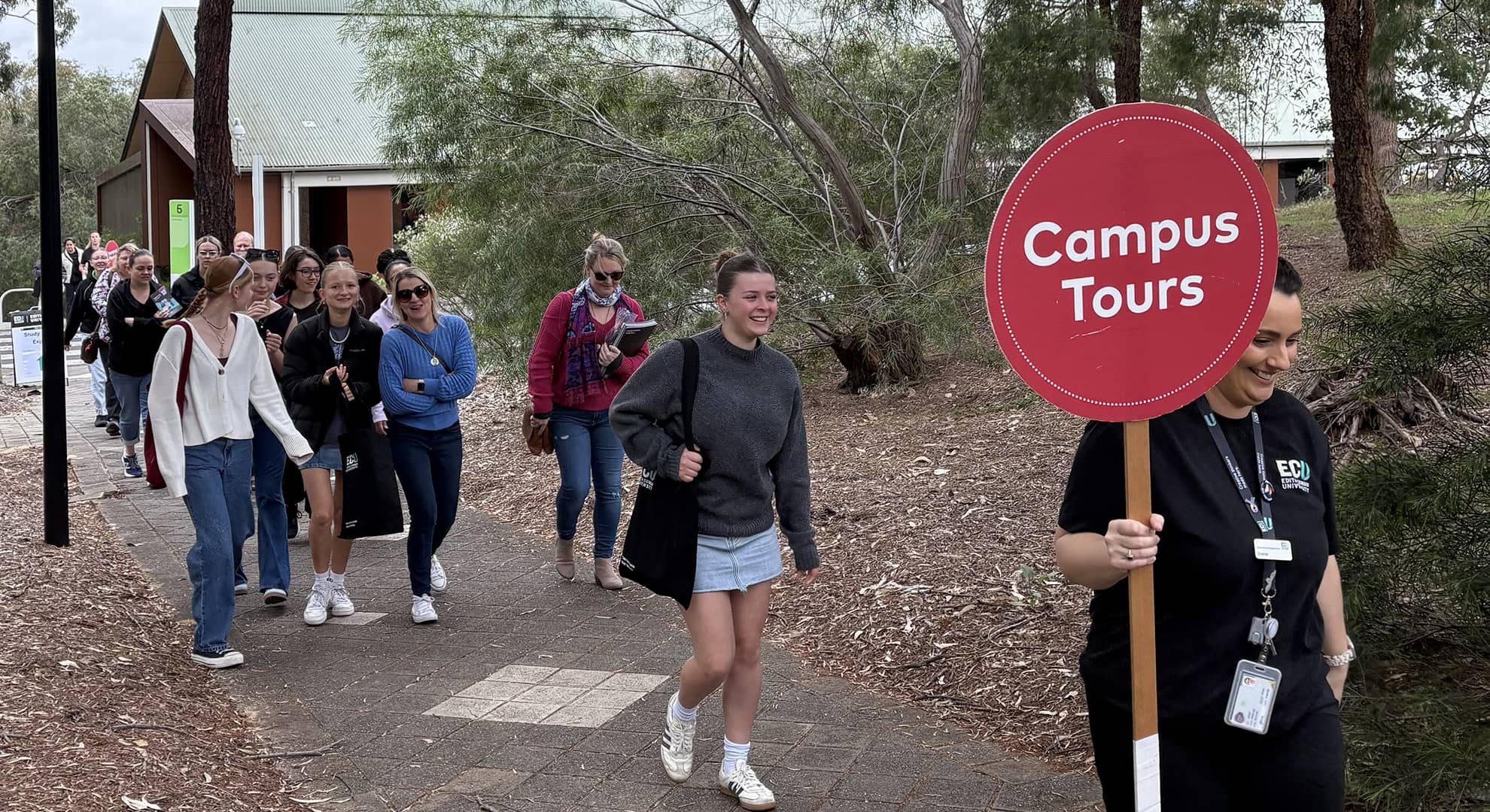 Group of students following the ECU staff member with Campus Tours sing