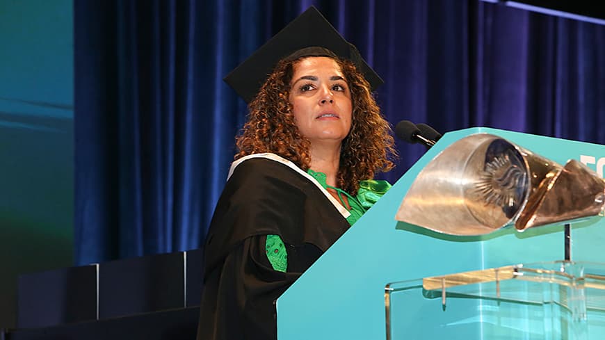 A woman giving a speech at a graduation ceremony