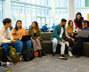 Students at ECU gathered around their laptops in the Library. 