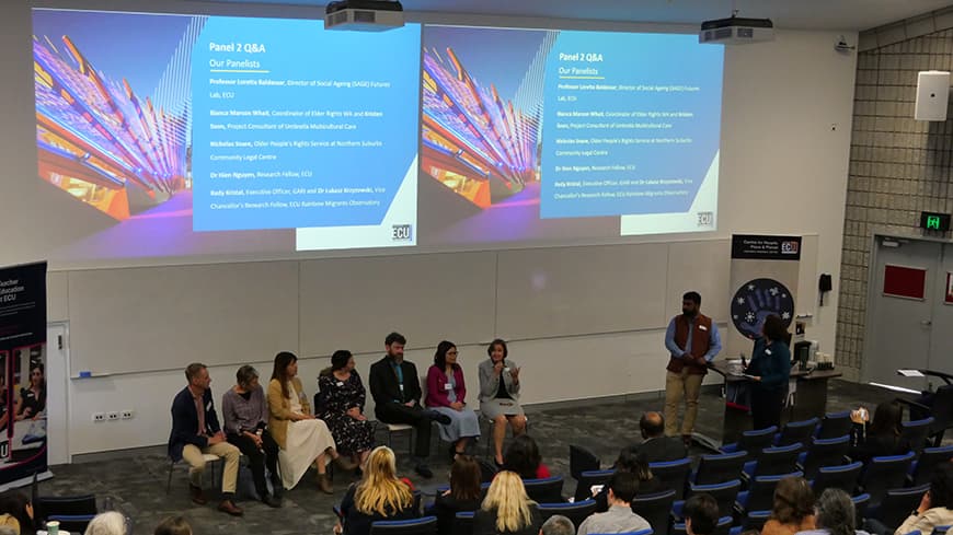 A group of panellists have a discussion about mobility justice in a lecture hall.