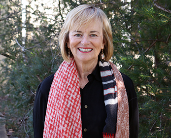 A pportrait image of Mrs Marilyn Schmidt smiling in front of trees