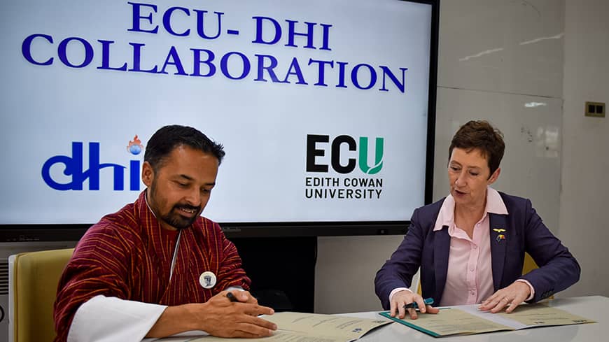 Two people signing a document