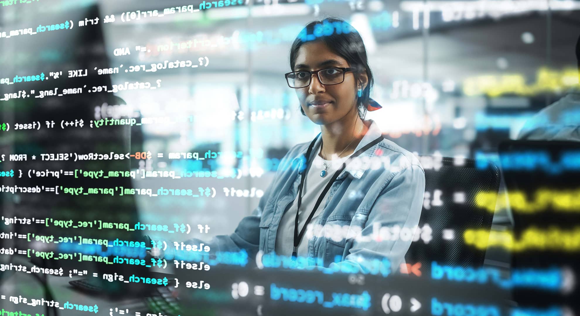 A young woman looking at a screen of computer code