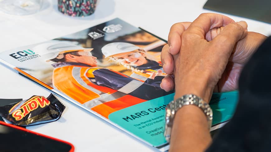 A MARS brochure on table, with hands.