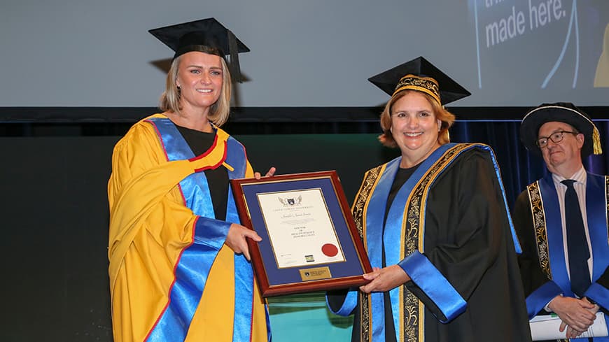 A woman, Jenni Screen, receiving an award from a woman, ECU Chancellor Gaye McMath