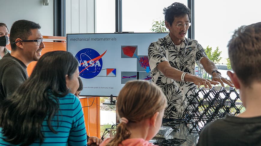 A man showing children a plastic structure