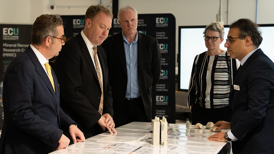 Four men and a woman around a table.
