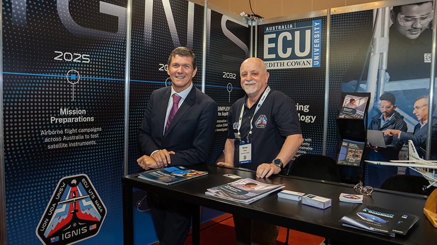 Two men at a trade conference stand