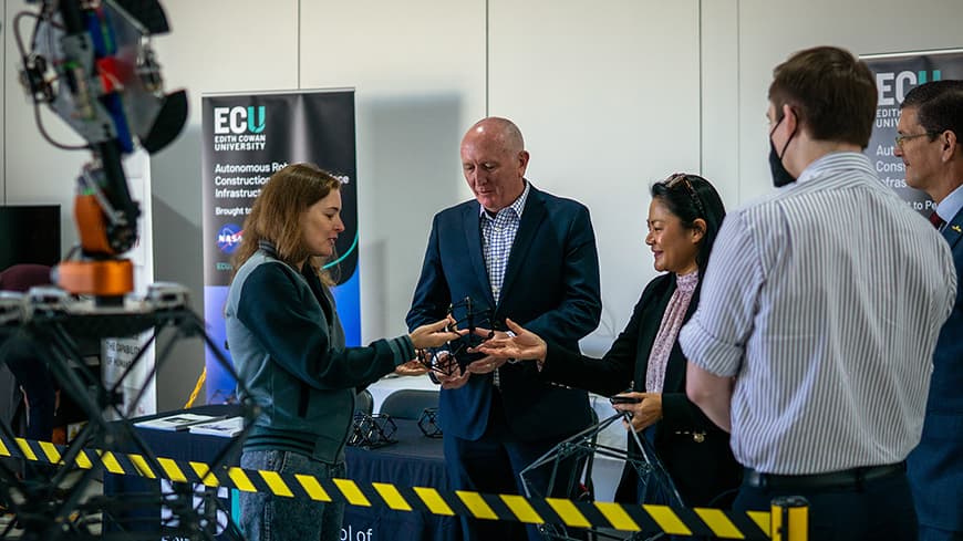A woman showing people a plastic object.