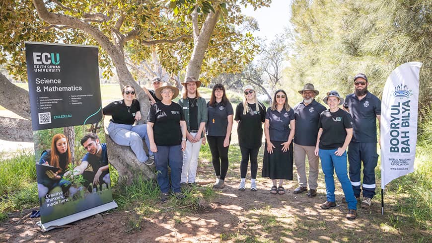 A group of people standing between two banners.