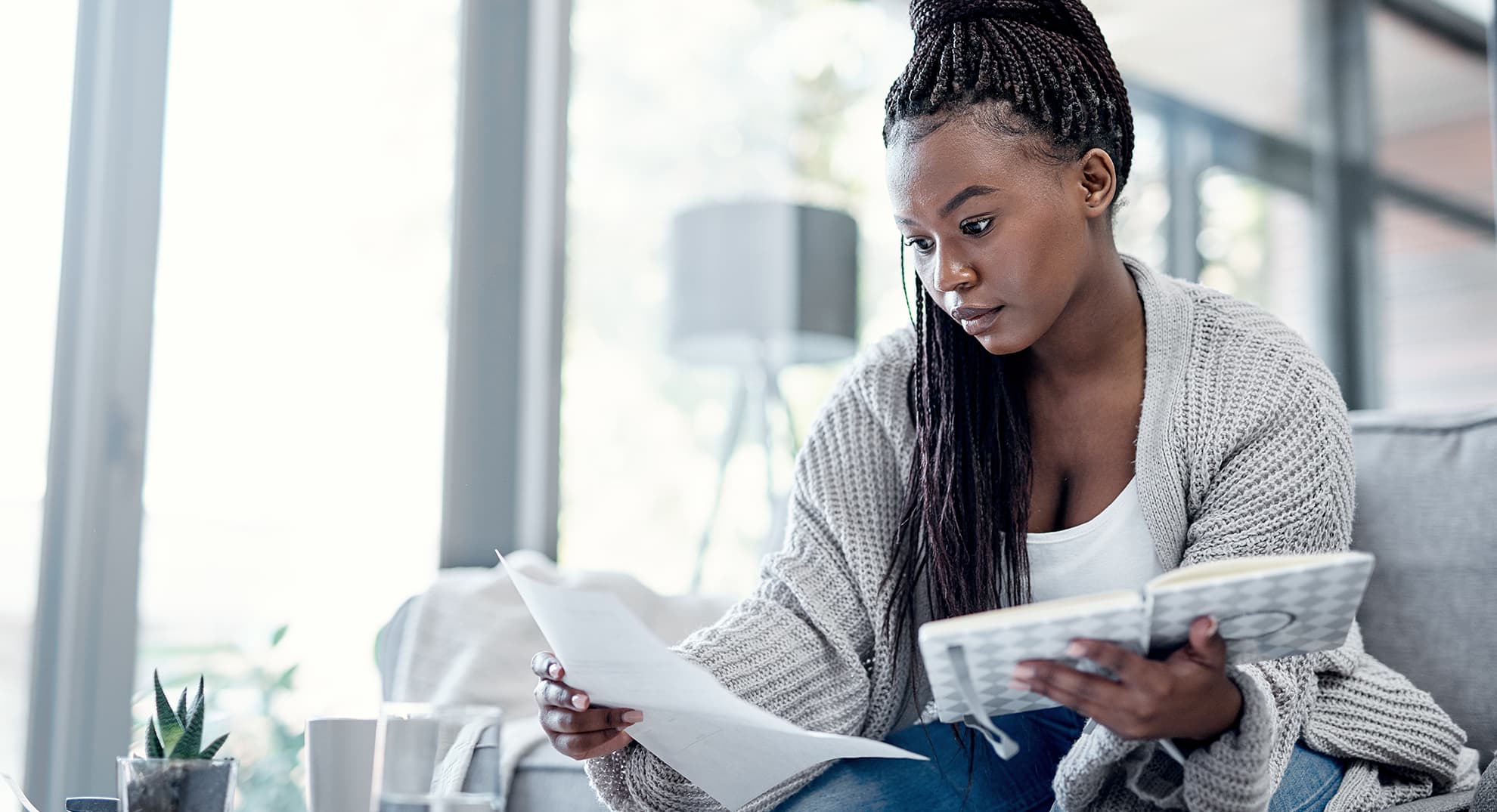 Young woman consulting her dairy and other papers