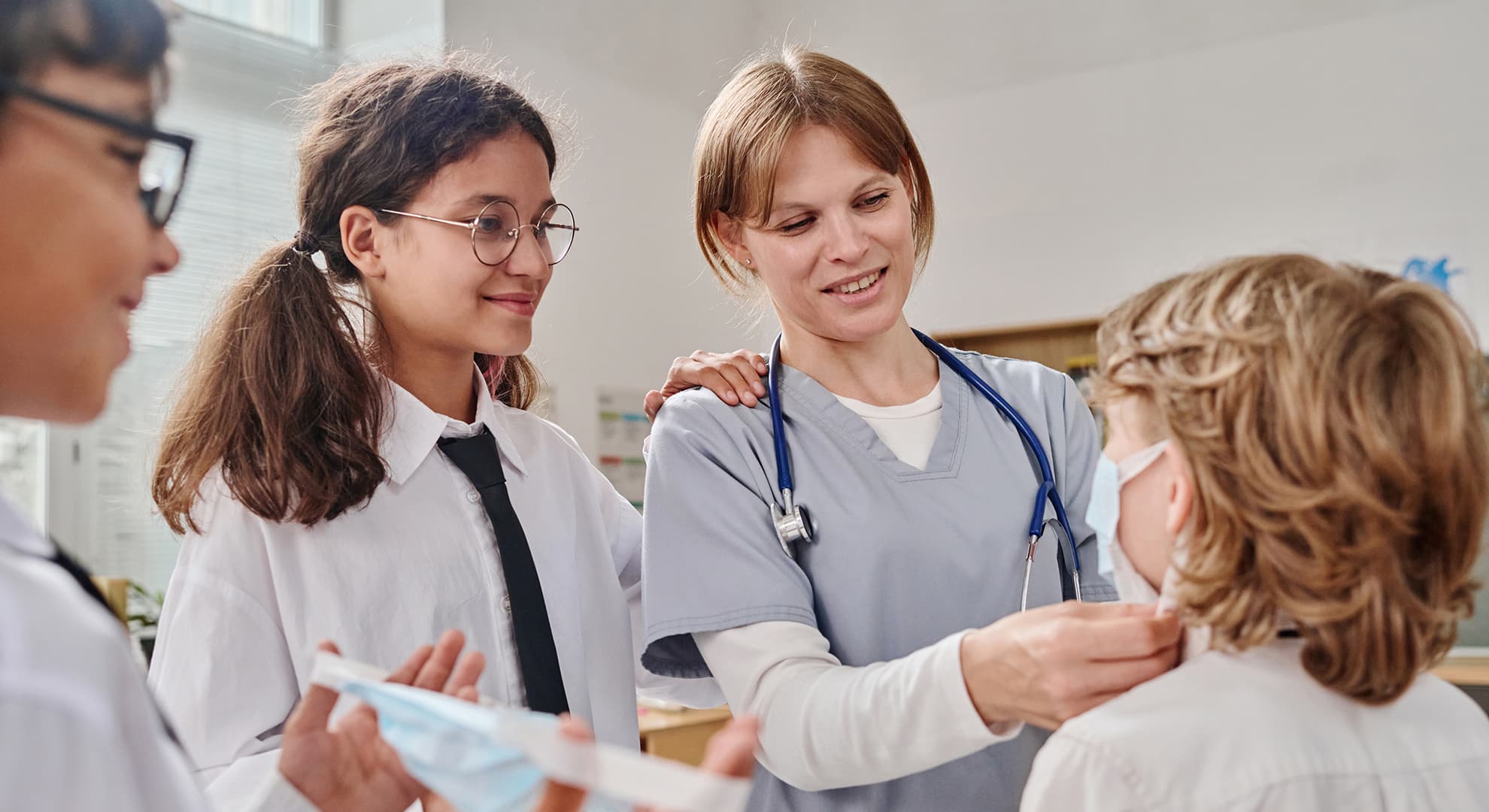 Female nurse looking at school children.