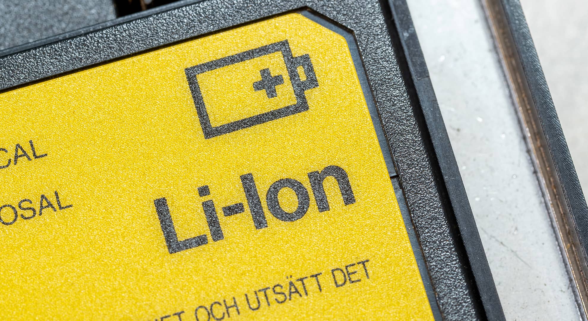 Yellow sticker on black battery saying Lithium Ion battery.