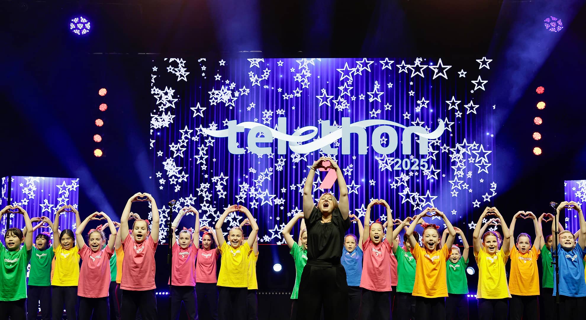 Children singing on stage at an event