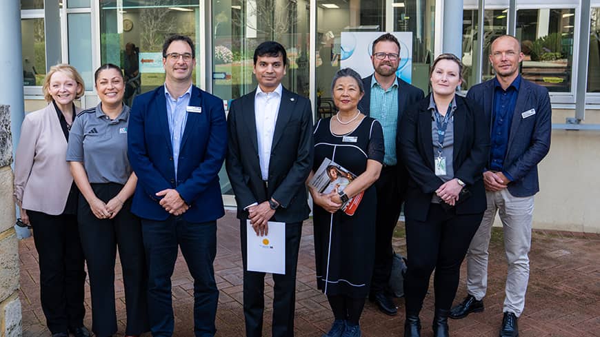 A group shot of men and women outside a building.