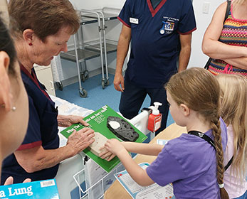 Children interacting with ECU staff members to learn about Medical and Health Sciences.