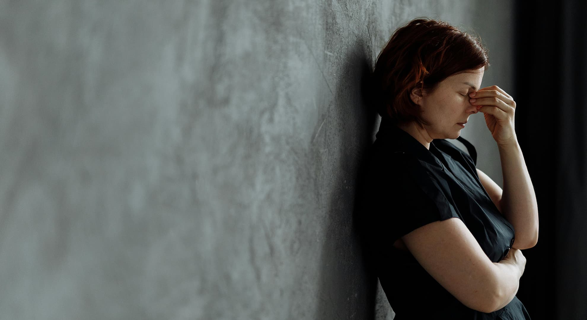 Person looking stressed with hands over face.