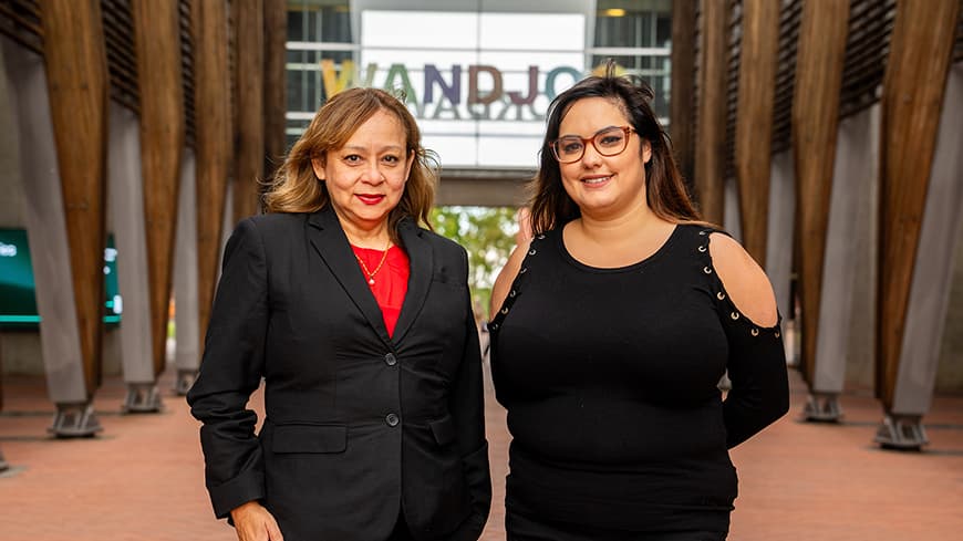 Two people standing next to each other in the central walkway outside ECU Joondalup\'s main building 1