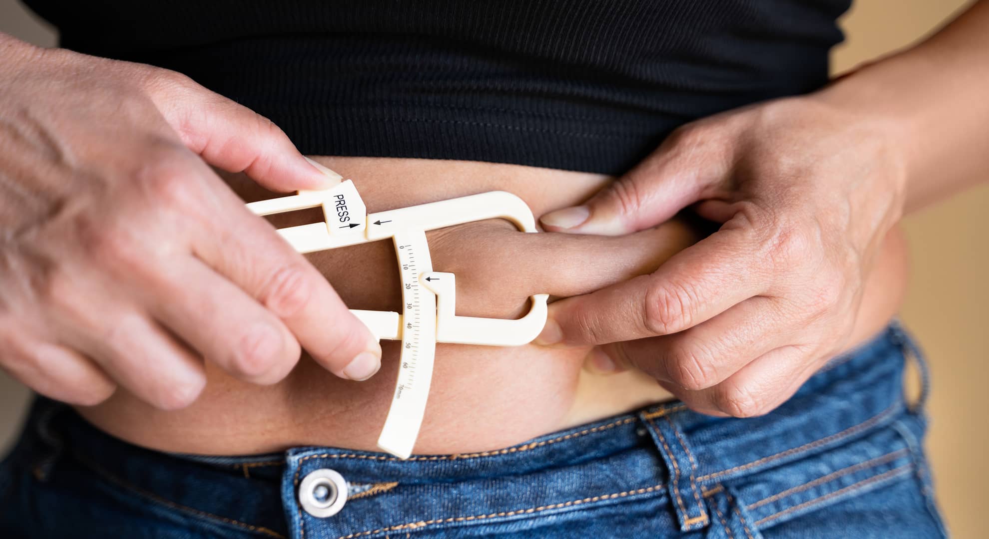Close up of a person measuring their waist.
