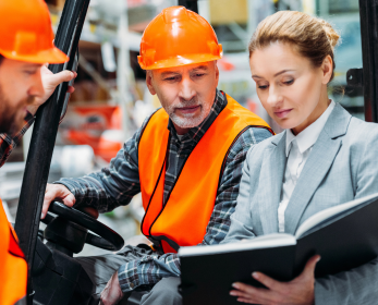 woman with safety folder instructing two men