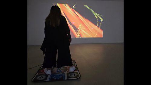 Woman playing an interactive video game infront of holographic image