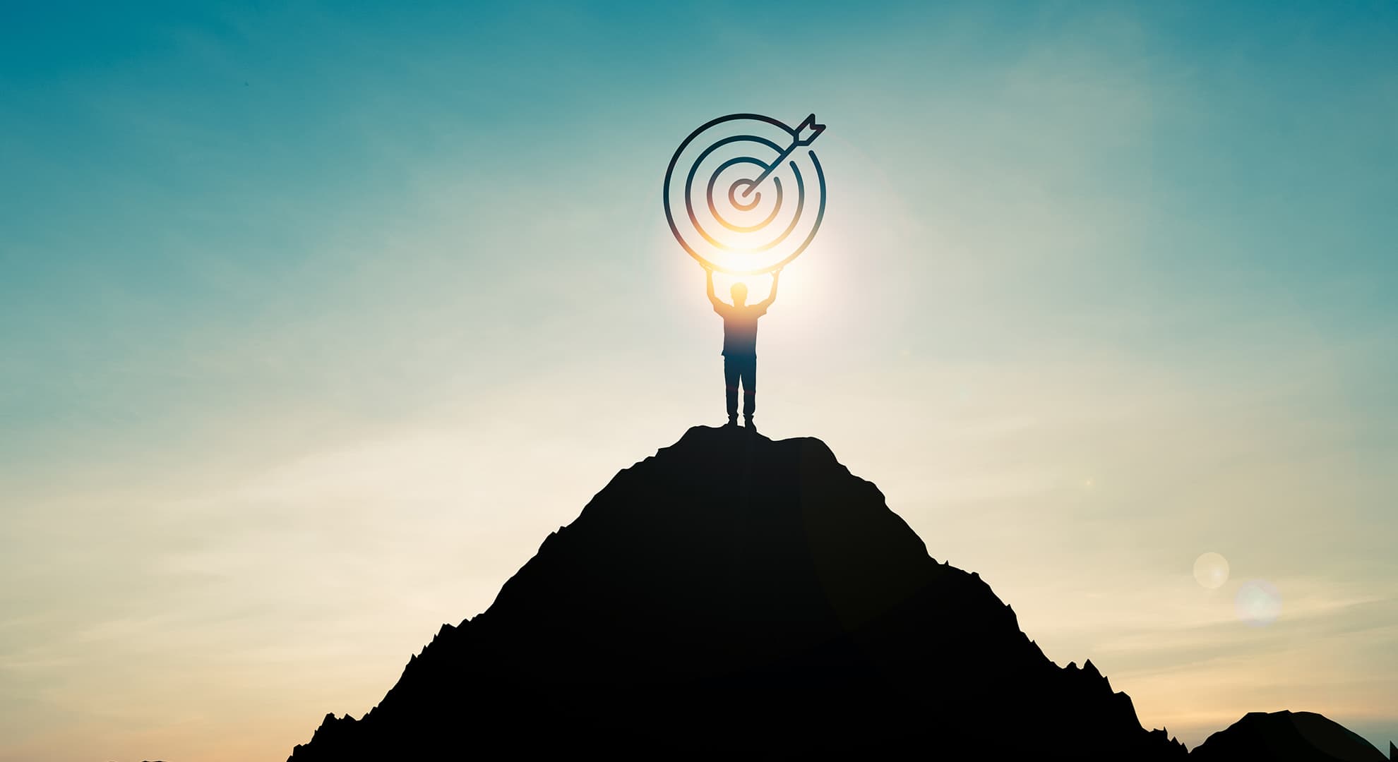 Person on top of a mountain holding a bulls eye.
